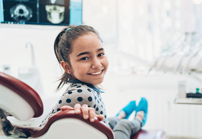 young, smiling girl sitting in a dental chair